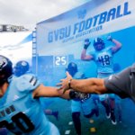 GVSU Football players run onto the field in front of blue smoke on November 2, 2024